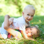 Brother and sister playing on grass